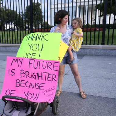 madre con figlia in braccio ringrazia Joe Biden per la scelta di ritirarsi dalla competizione per la casa bianca