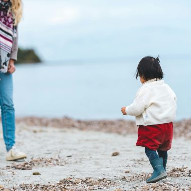 mamma con bambina sulla spiaggia in inverno