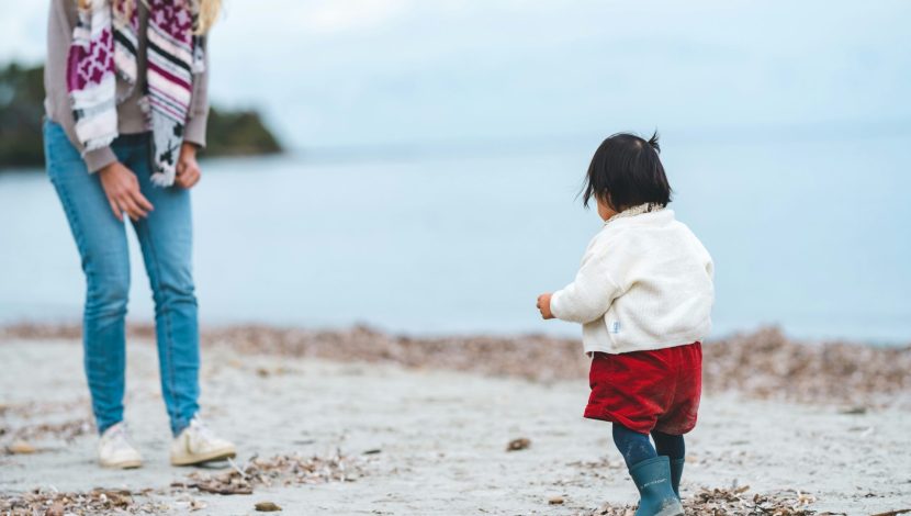 mamma con bambina sulla spiaggia in inverno