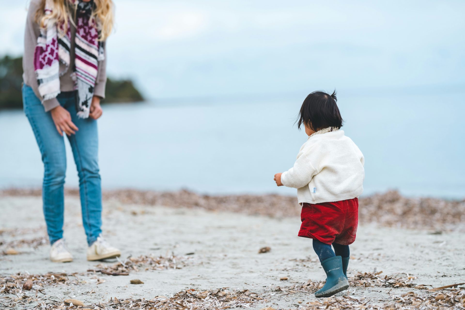 mamma con bambina sulla spiaggia in inverno