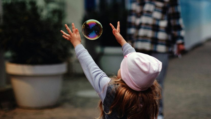 bambina gioca con le bolle di sapone