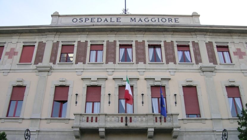 La facciata di un edificio, sul balcone c'è una bandiera italiana e una europea, in alto c'è scritto "Ospedale maggiore"